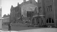 People walking on a bombed-out street.