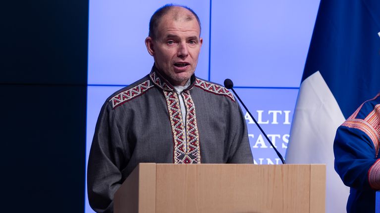 Saamelaisten totuus- ja sovintokomission tiedotustilaisuudessa Veikko Feodoroff puhujankorokkeella. Taustalla näkyy Suomen lippu.