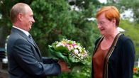 Vladimir Putin presents a bouquet of flowers to Tarja Halonen.