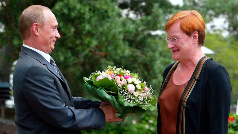 Vladimir Putin presents a bouquet of flowers to Tarja Halonen.