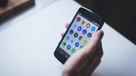 Mobiltelefon  i handen ljus bakgrund