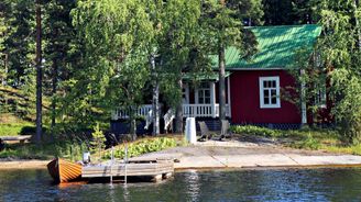 Kesämökki, laituri ja soutuvene Saimaalla.