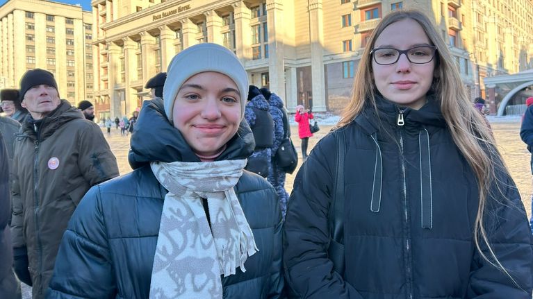 Kaksi nuorta naista seisoo Maneesiaukiolla. Takana näkyy hotelli Moskvan julkisivu.