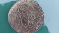 Photo shows an old coin.