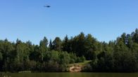 En helikopter flyger över olycksplatsen