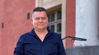 Mies seisoo teatterin ulkoportailla.