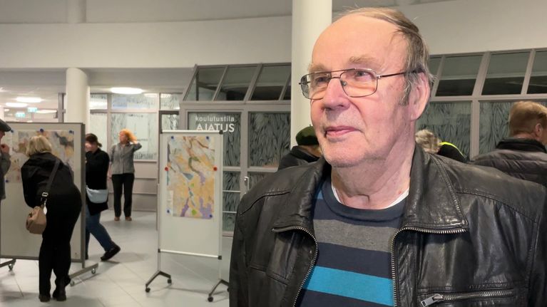 Silmälasipäinen mies aulassa.