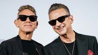 Martin Gore och Dave Gahan ler och bär solglasögon.