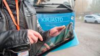 Mies käyttää tablettia digikirjastoauton edessä.