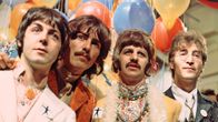 The Beatles poseeraa värikkäissä vaatteissa muutaman ilmapallon edessä.