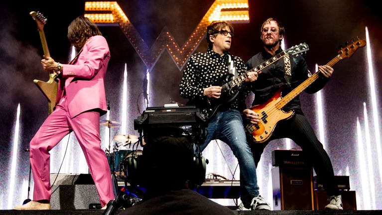 Rockbandet Weezer uppträder på scen.