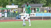 En fotbollsspelare står med bollen i fötterna.