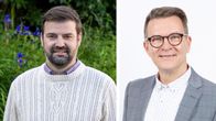 Två män en med vit ylletröja, de andra i grå kavaj.