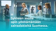 Sairaalasarjan henkilökunta vastaanottotiskin ympärillä.