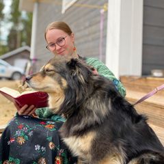 Ruut Tervaniemi lukee raamattua ja rapsuttaa koiriaan.
