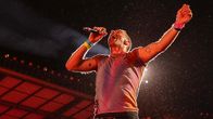 Chris Martin laulaa mikkiin lavalla ja hyppää ilmaan.