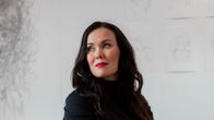 Katriina Haikala isuu tuolissa sylissään piirroslehtiö.