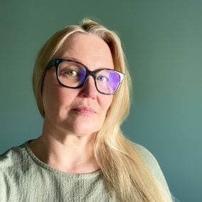 Nainen tuijottaa kameraan.
