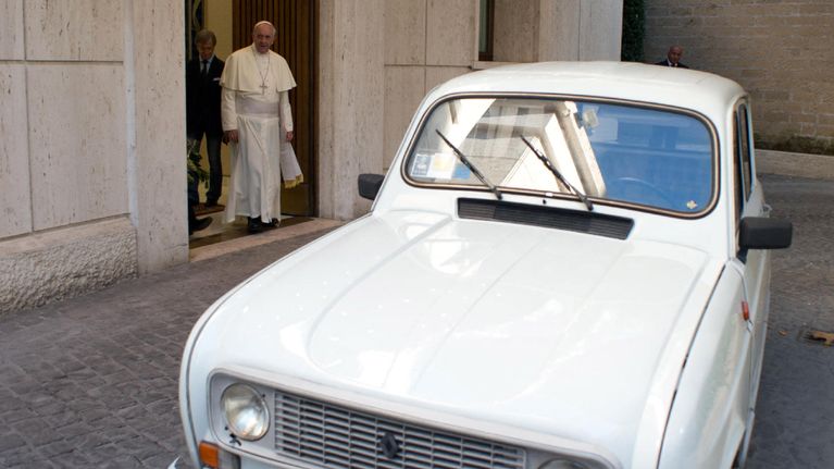 Paavi Franciskus katsoo hänelle lahjoitettua valkoista Renaultia.