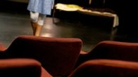 Tyhjiä penkkejä teatterin katsomossa.
