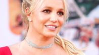 Britney Spears poseeraa punaisessa puvussa ja punaisella matolla.