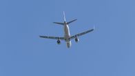 A Finnair plane rising through the sky, shot from an underneath vantage point.