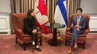 Sanna Marin ja Justin Trudeau tapasivat Brysselissä. Taustalla Suomen ja Kanadan liput. 