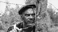 Pertti Pasanen piikkilanka-aidan takana.