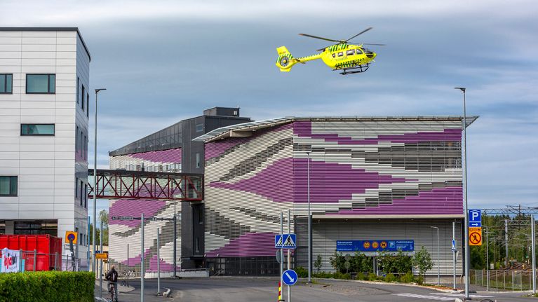 Lääkintähelikopteri nousemassa pysäköintihallin päältä lentoon.
