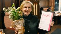 Vuoden kaupunkilainen on helsinkiläinen, harrastajavalokuvaaja Marit Henriksson kukkien ja kunniakirjan kanssa.