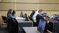 Käräjäoikeuden istuntosali, ihmisiä istumassa pöytien äärellä, syytetyt peittäneet kasvonsa