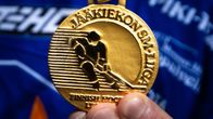 Lähikuvassa jääkiekon SM-liigan kultamitali pelaajan kädessä. 