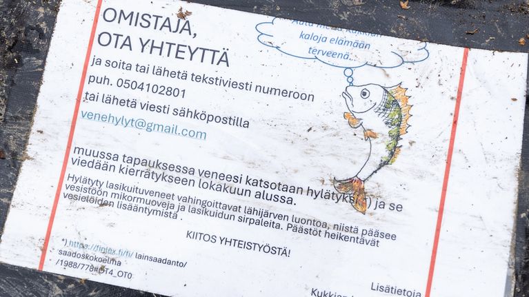 Veneeseen teipillä liimattu viesti, jossa pyydetään ottamaan yhteyttä, mikäli vene on käytössä.