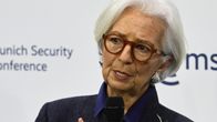 Christine Lagarde puhuu mikrofoniin ja elehtii käsillään.