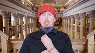 Kuvassa Viikon Tuukka eli toimittaja Tuukka Pasanen katsoo kameraan Kansalliskirjastossa yrittäen näyttää tärkeältä