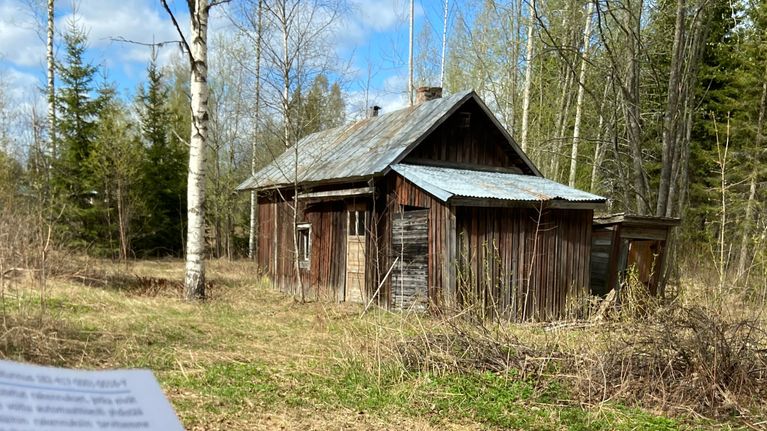 Kuvassa on etualalla Jämsän kaupungin konsultin lähettämä tietopyyntökirje, jossa on ilmakuva kiinteistöstä, ja punaisella on merkitty sen rakennuksen katto, josta ei löydy rekisteritietoja. Taustalla näkyy ränsistynyt autiotalon saunarakennus, josta ilmakuva on otettuka 