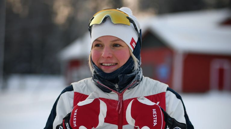 Anni Lindroos tittar till höger och lutar sig mot sina stavar.