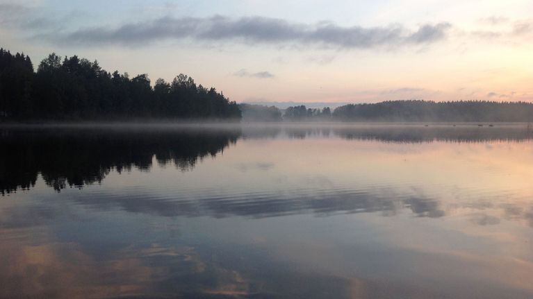 Järvi kesäyössä, pinnalla sumua.