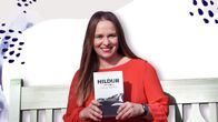 Kirjailija Satu Rämö pitää käsissään kirjaansa Hildur. Taustalla graafinen taustakuva.
