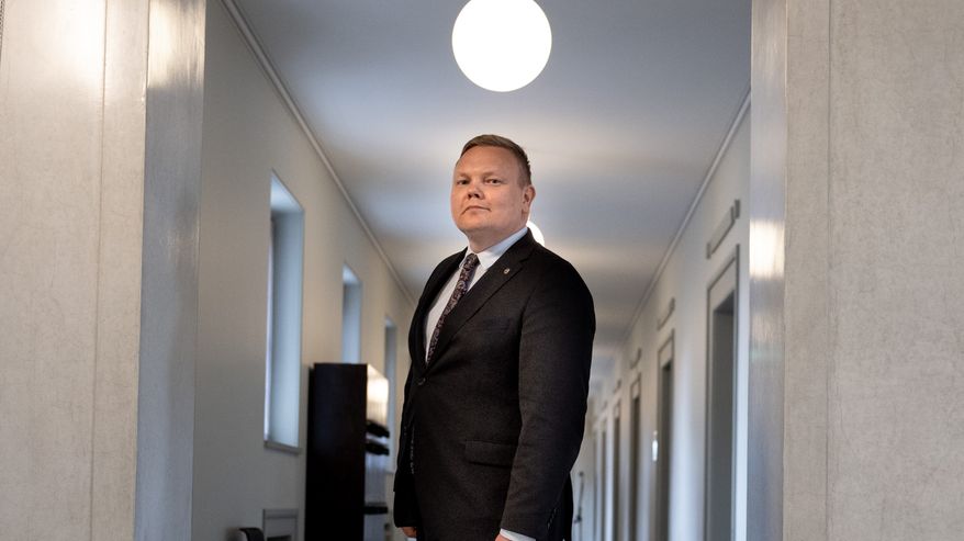 Mies seisoo keskellä valoisaa käytävää.