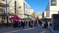 Ihmisiä vaaliteltoilla Jyväskylän keskustan kävelykadulla aurinkoisena talvipäivänä, etualalla punakattoinen vaaliteltta.