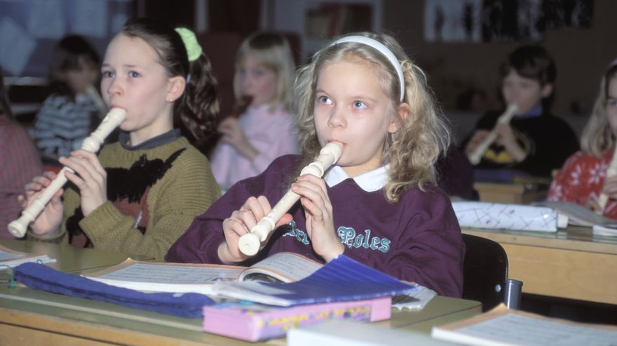 Lapset soittavat nokkahuilua musiikin tunnilla luokkahuoneessa vuonna 1990.