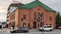 Punatiilinen Kemin Pirtti Valtakadun ja Kauppakadun risteyksessä. Seinässä teatterinäytöksen mainosjuliste.