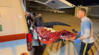 Palestiinalaista viedään paareilla ambulanssiin.