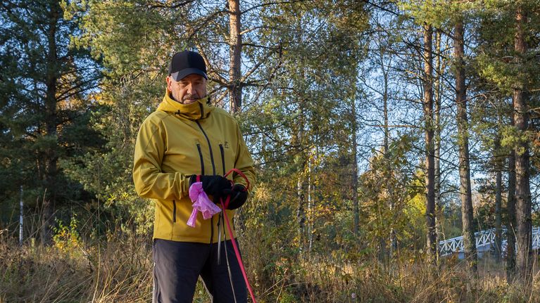 Mies kahden koiran kanssa ulkoilemassa.