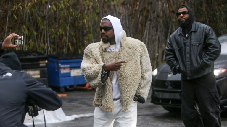 Kanye West poseeraa kuvaajille kadulla.
