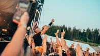 Publiken räcker upp händerna medan en artist uppträder.