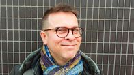 Muusikko Jukka Perko katsoo hymyillen kohti kameraa.