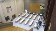 Ylhäältä päin otetussa kuvassa näkyy valkoisia pöytiä ja tuoleja. 