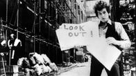 Bob Dylan esittelee sanakylttejä "musiikkivideossa" Subterranean Homesick Blues, taustalla Allen Ginsberg. Kuva D.A. Pennebakerin ohjaamasta dokumenttielokuvasta Don't Look Back (1967).